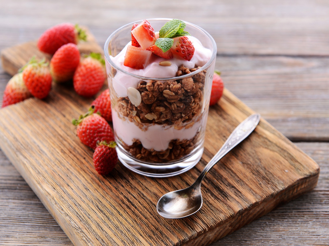 Овсяные хлопья в стакане с йогуртом и ягодами клубники