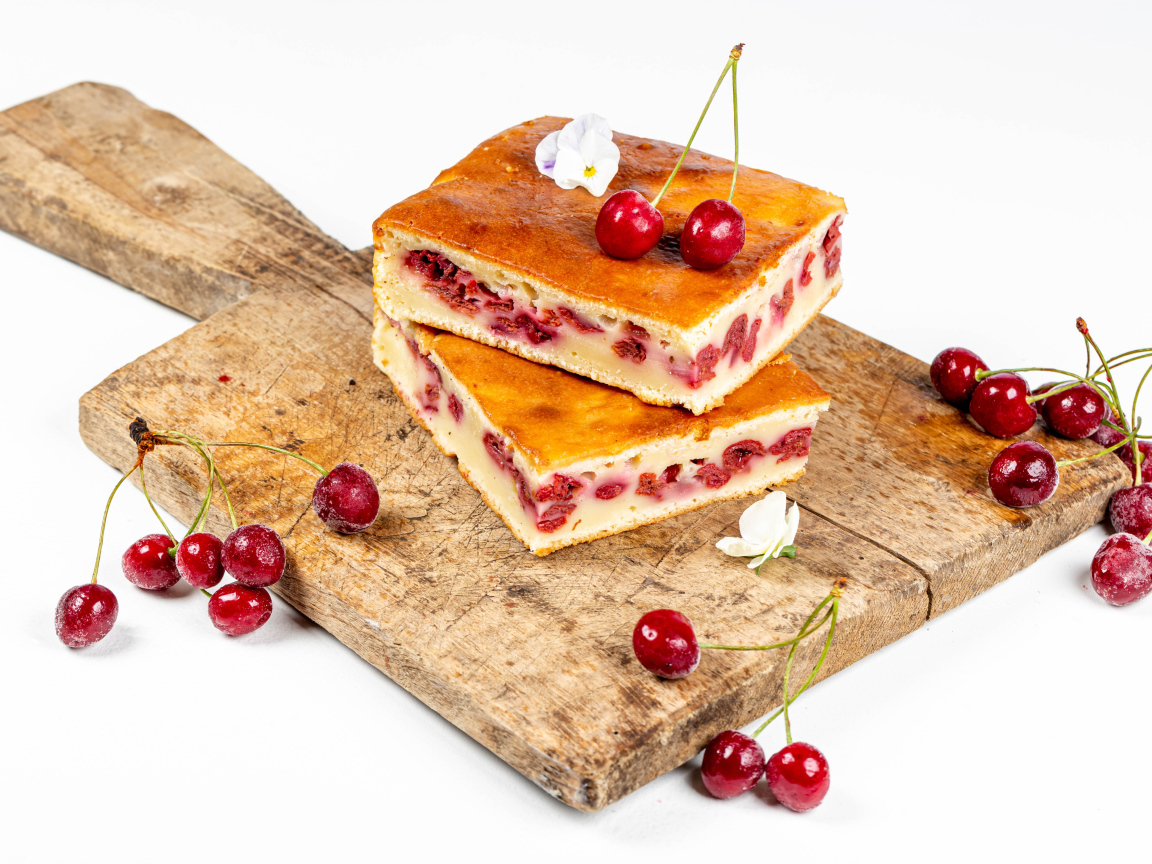 Пирог с вишнями на доске на белом фоне