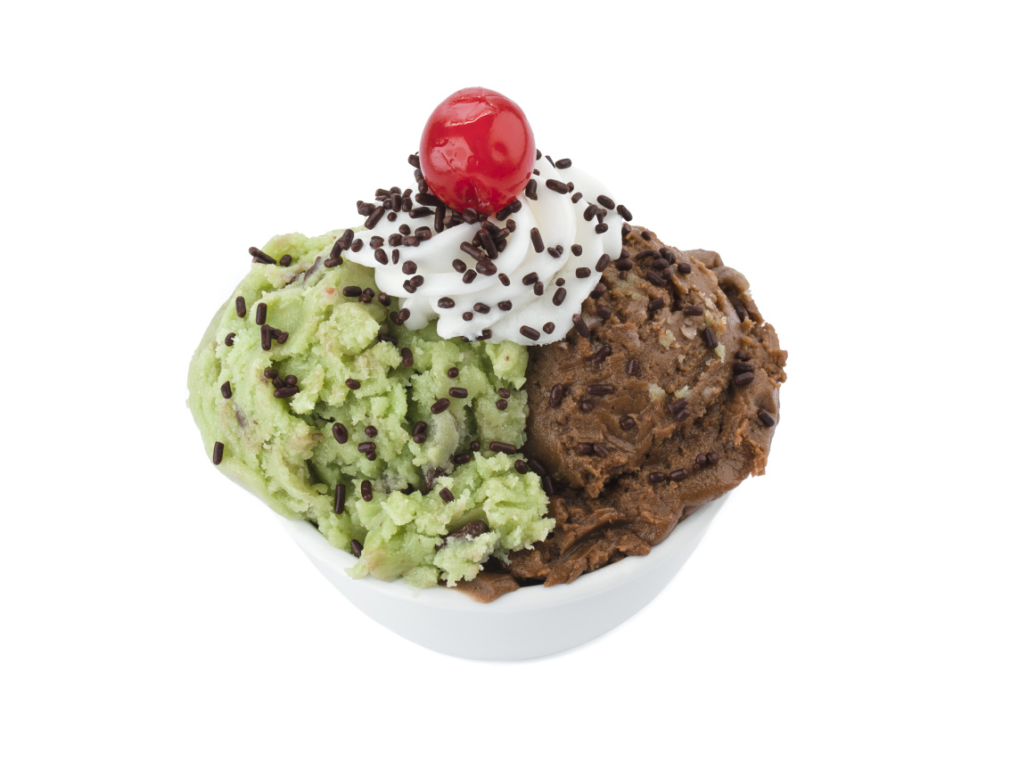 Фисташковое и шоколадное мороженое в креманке на белом фоне