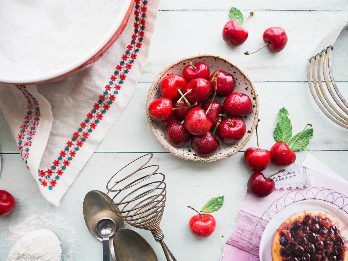 Мокрые ягоды черешни на столе с пирожным