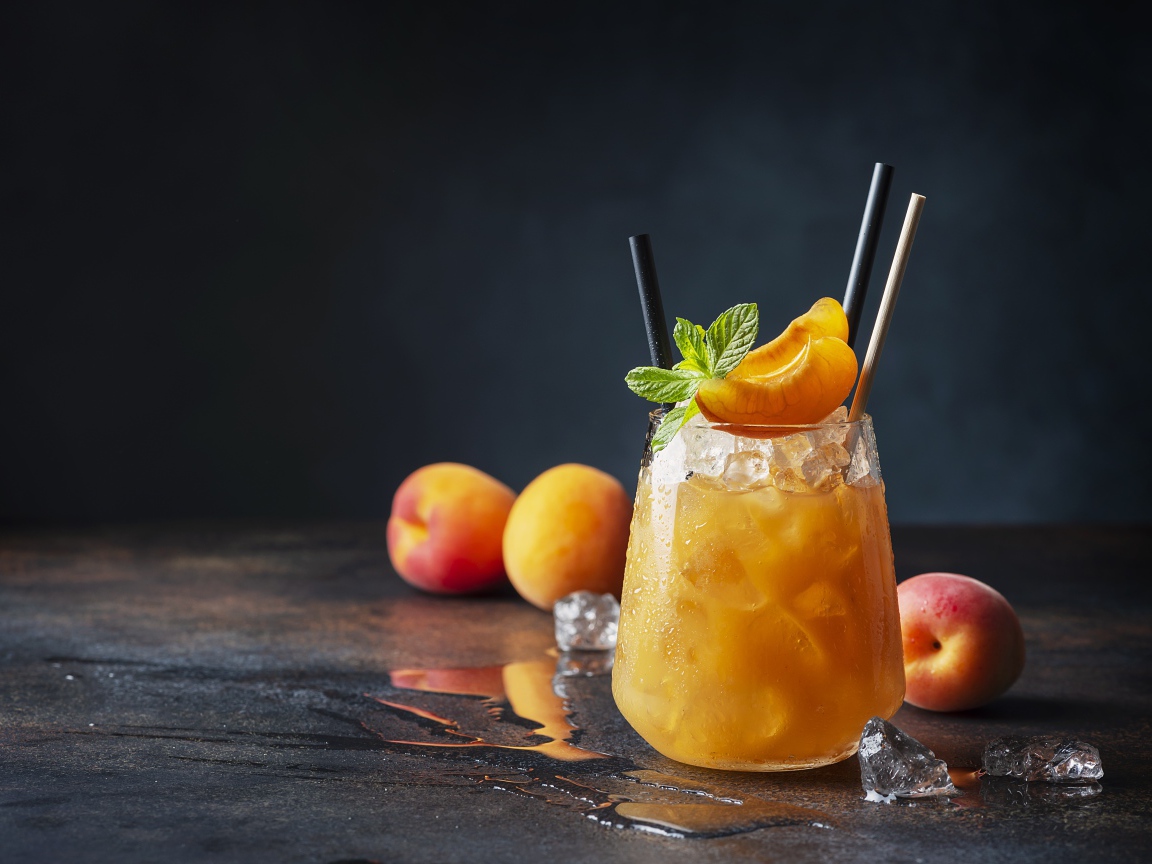Стакан абрикосового сока со льдом в стакане 