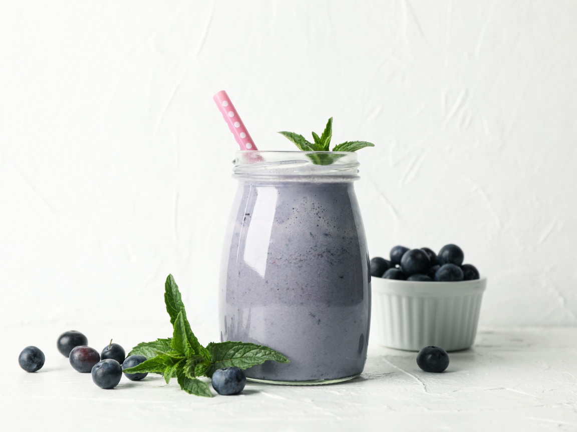 Черничный смузи в банке с мятой и свежими ягодами