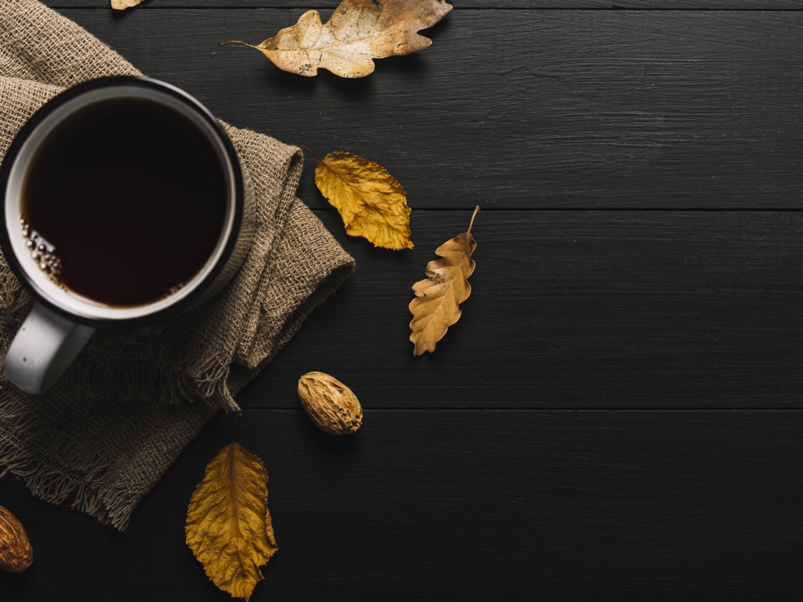 Чашка кофе на черном столе с листьями