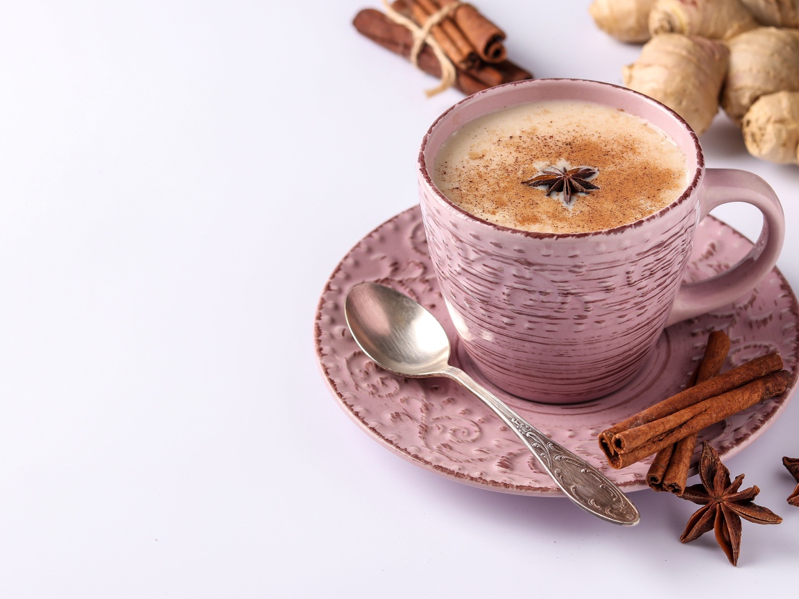 Чашка кофе на столе с корицей, бадьяном и  имбирем на белом фоне 