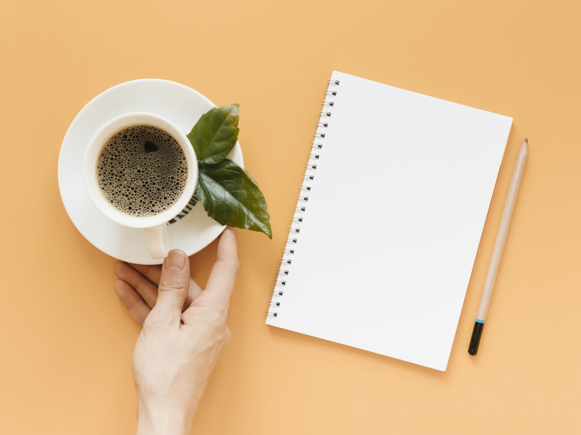 Чашка кофе на столе с блокнотом