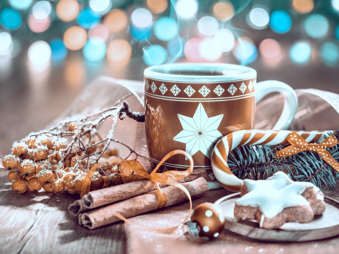 Чашка горячего кофе на столе с корицей и печеньем и веткой рябины