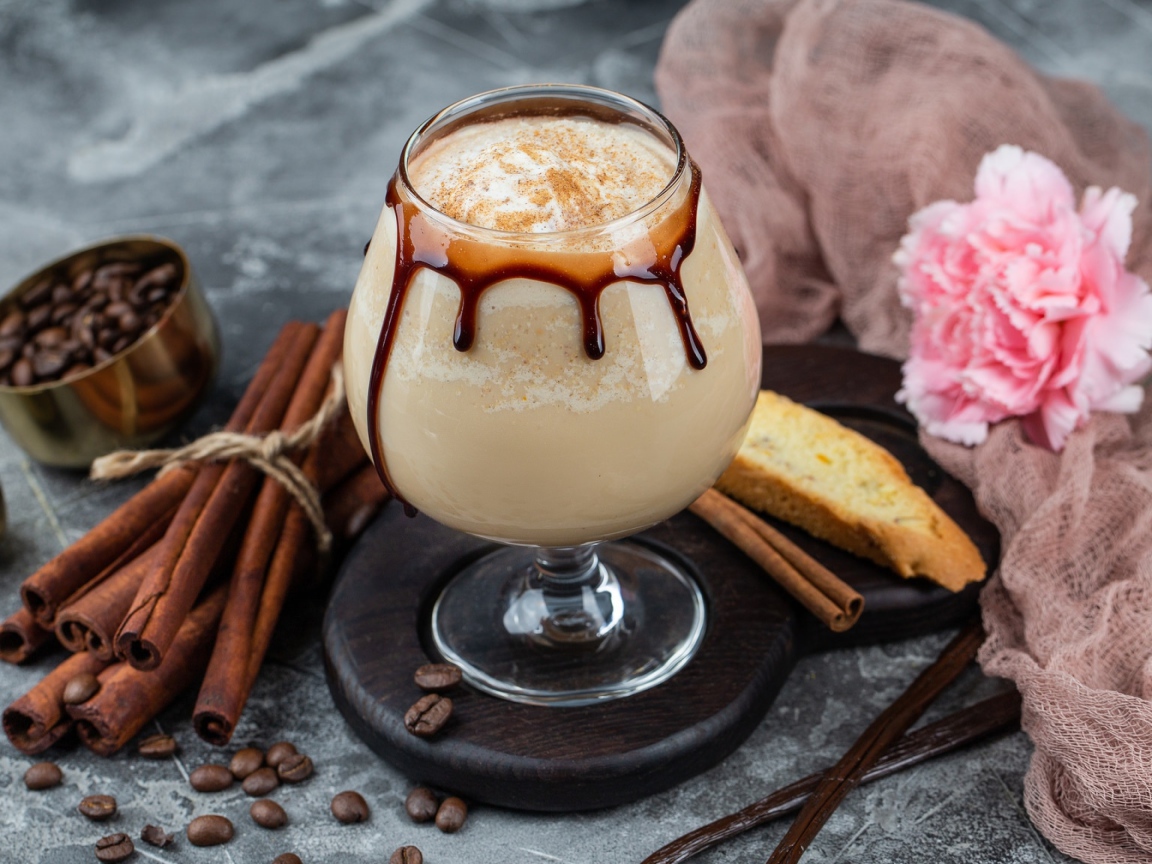 Вкусный кофейный напиток на столе с корицей и гвоздикой