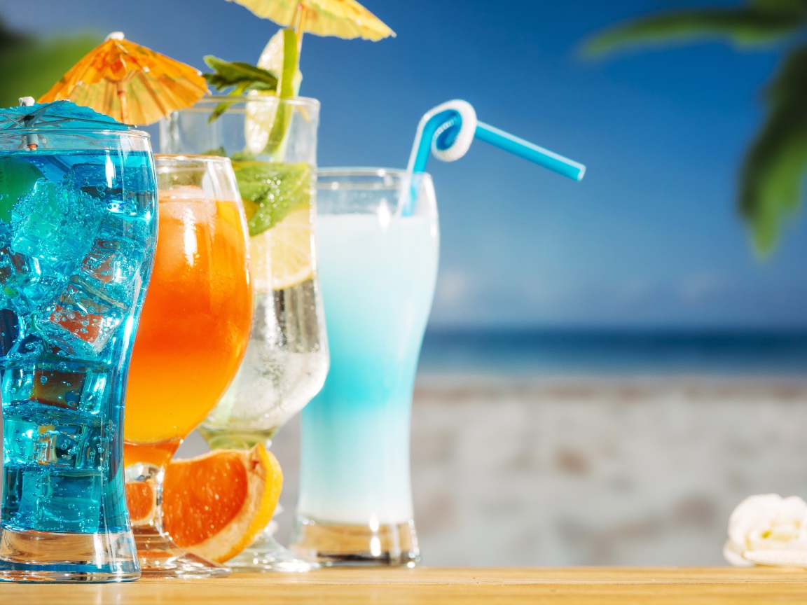 Четыре коктейля стоят на столе пляже 