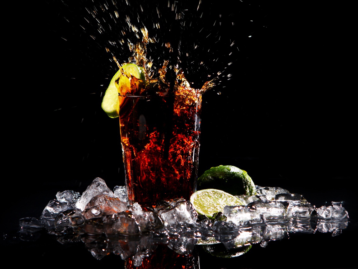 Стакан кока колы на черном фоне со льдом