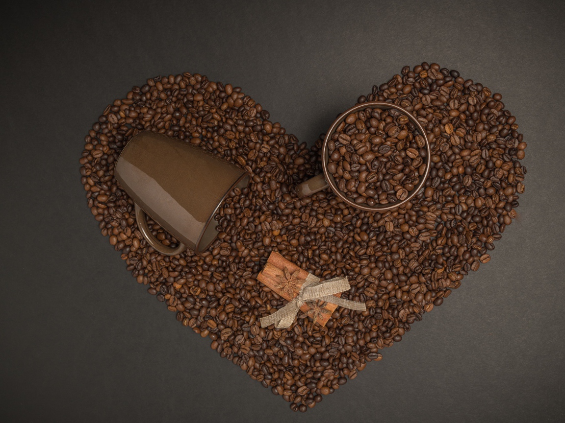 Сердце из кофейных зерен на сером фоне с кружками 