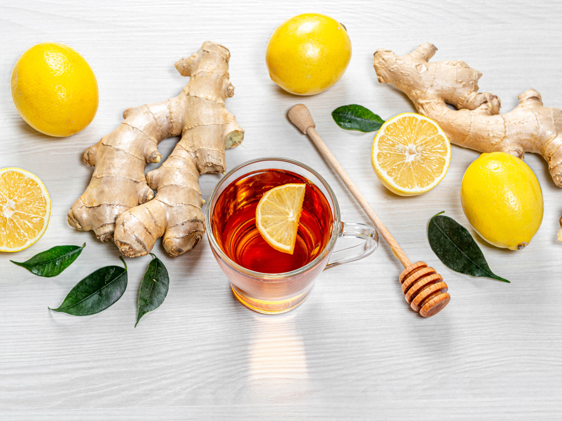 Чай в стеклянной чашке на столе с лимоном и имбирем 