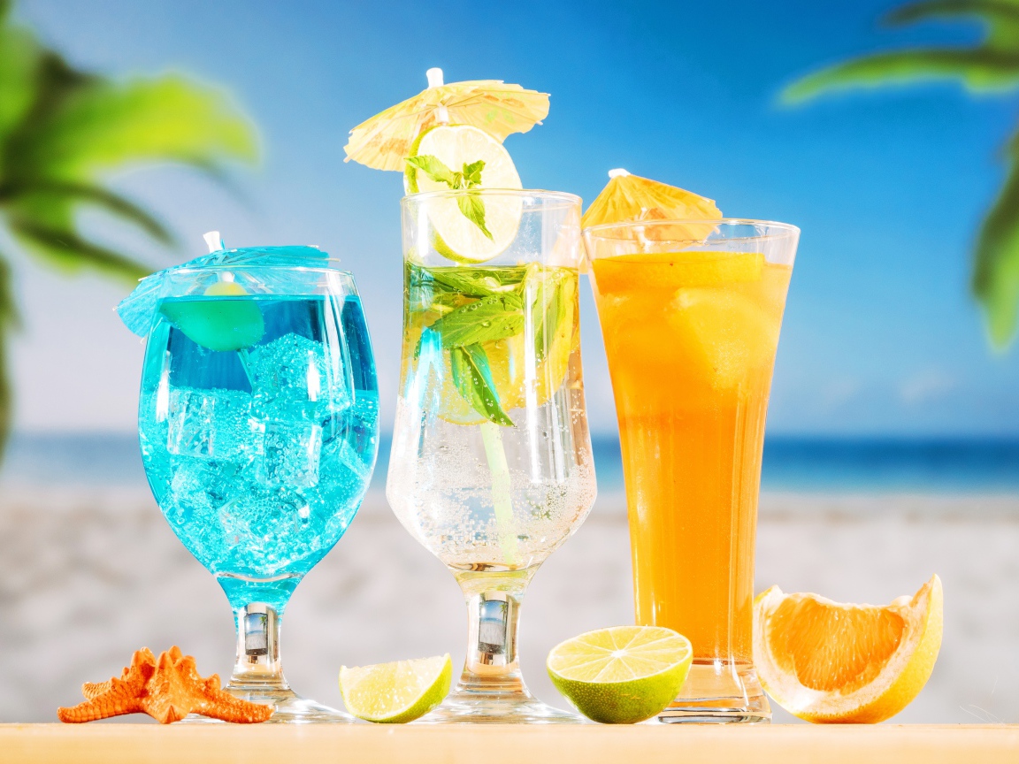 Три вкусных тропических коктейля стоят на пляже