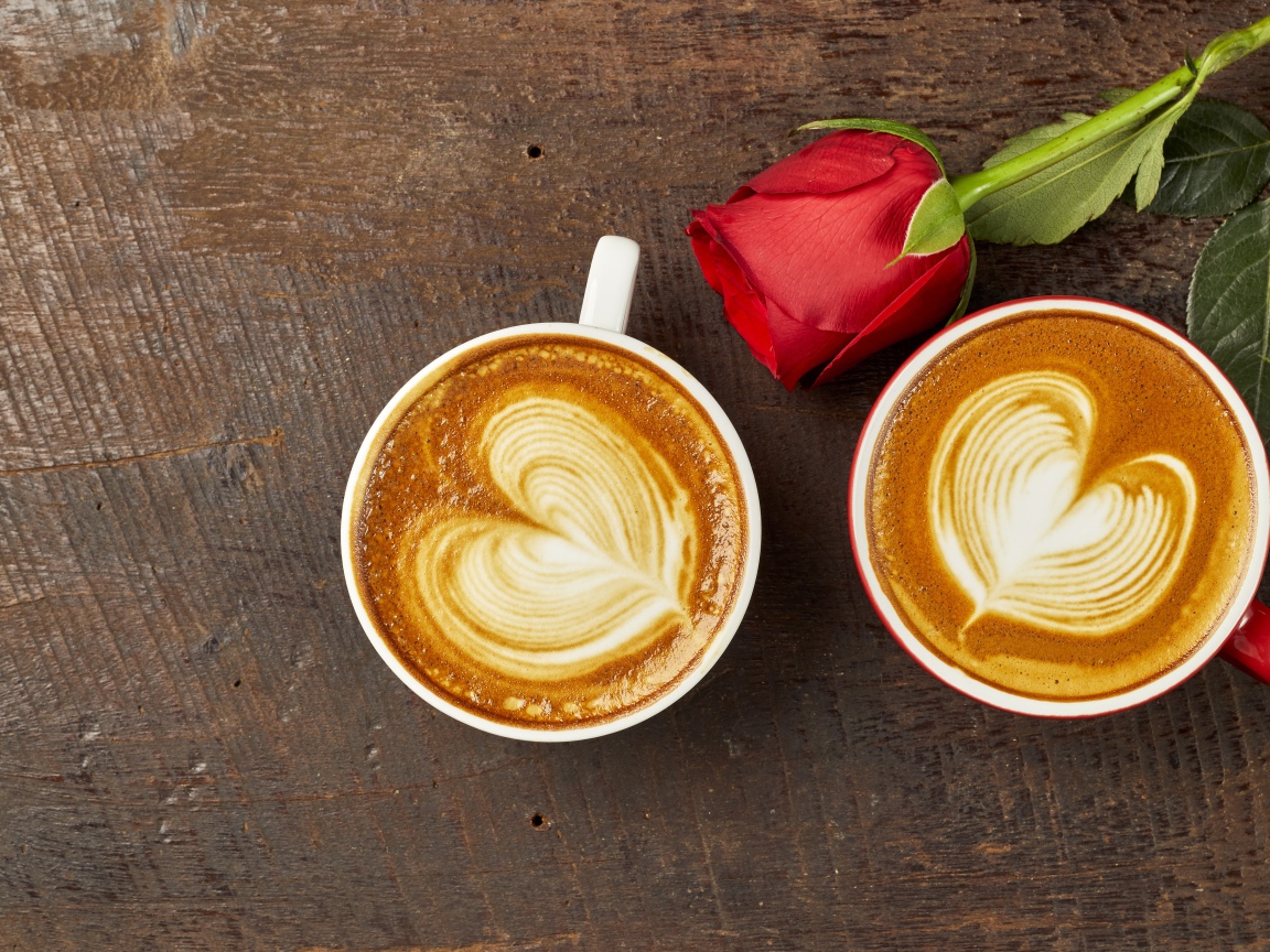 Две чашки капучино на столе с красной розой 