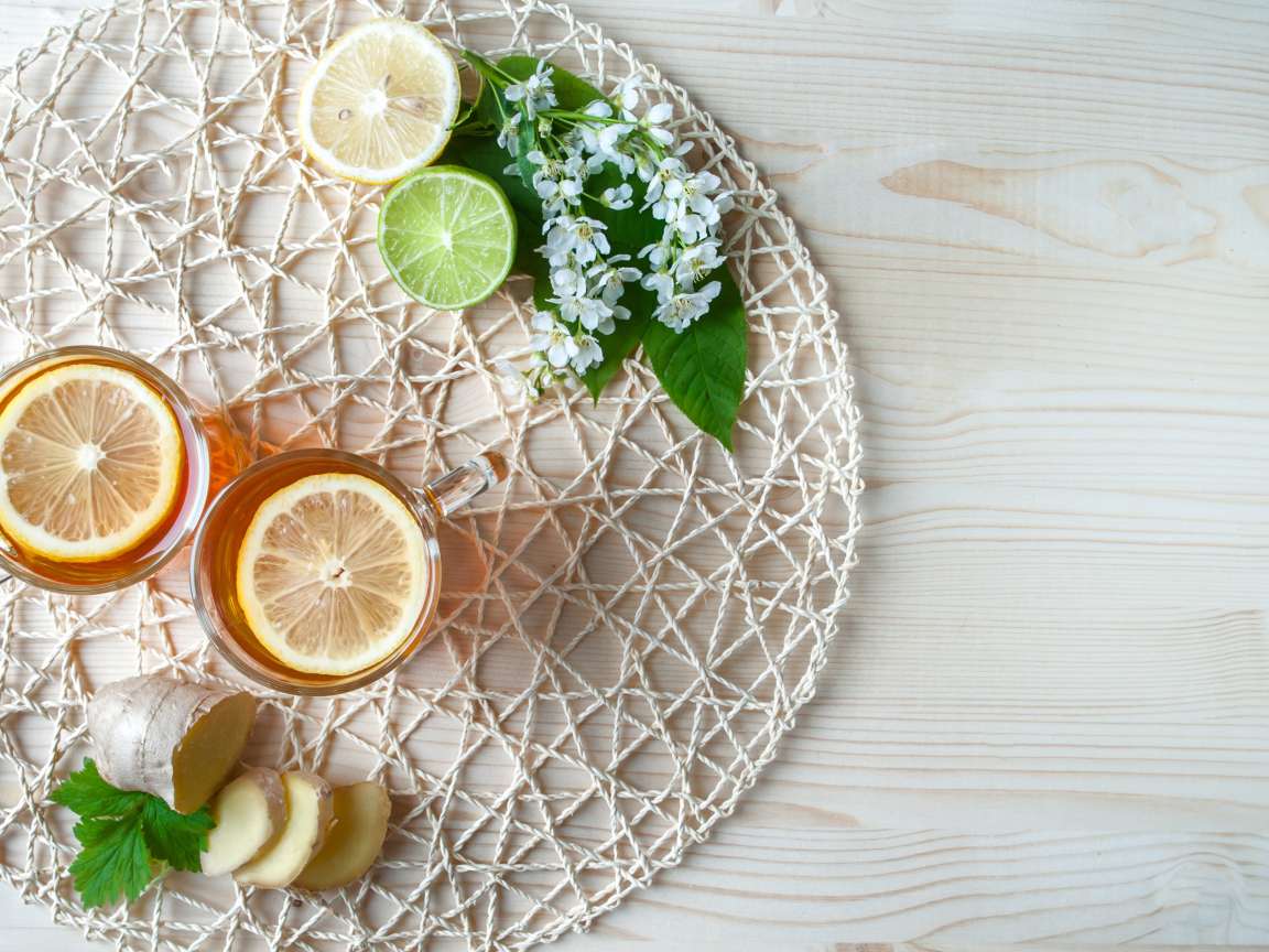 Две чашки чая с лимоном на плетеной подставке 