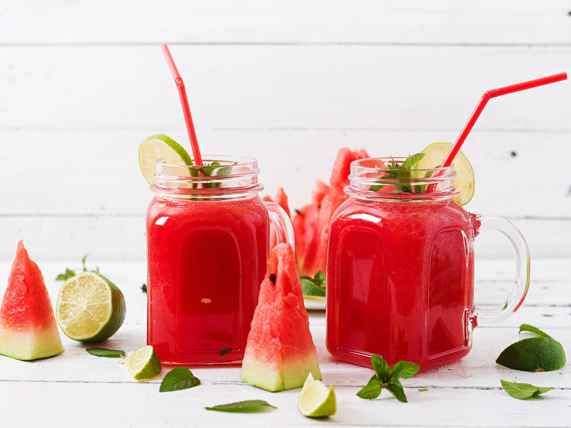 Арбузный коктейль на столе с лаймом и кусочками арбуза