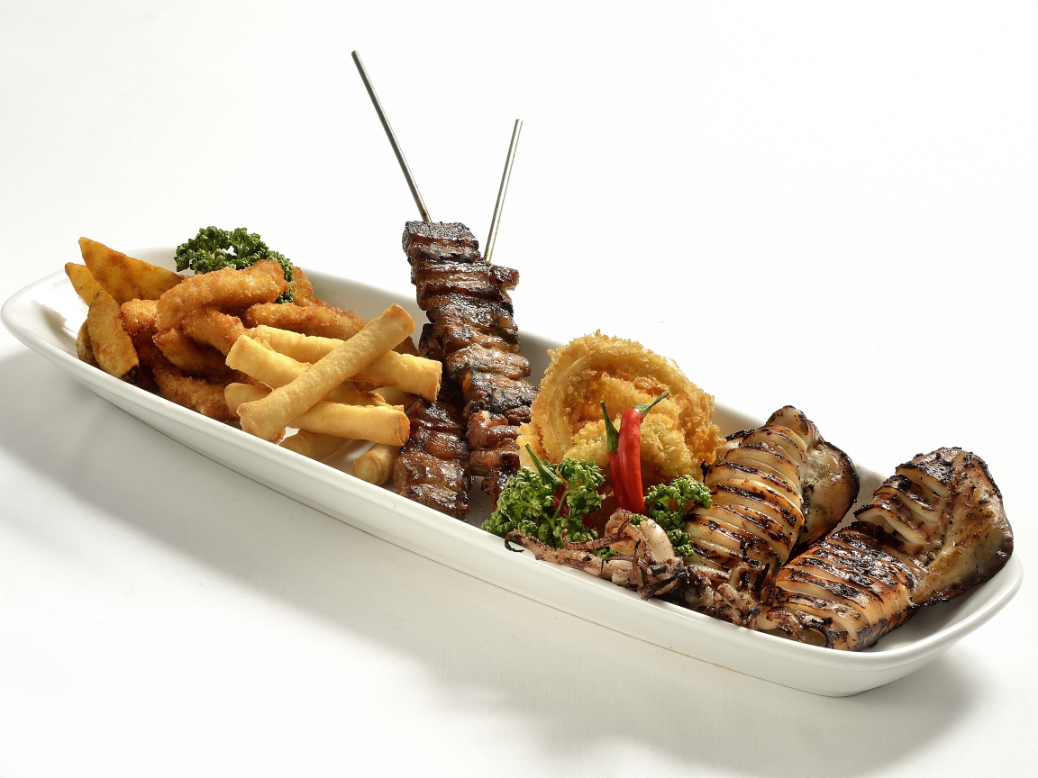 Мясо барбекю на тарелке с морепродуктами в кляре