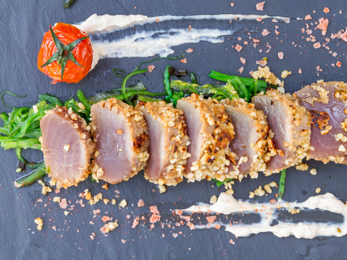 Вяленое мясо на столе с зеленью и помидором 