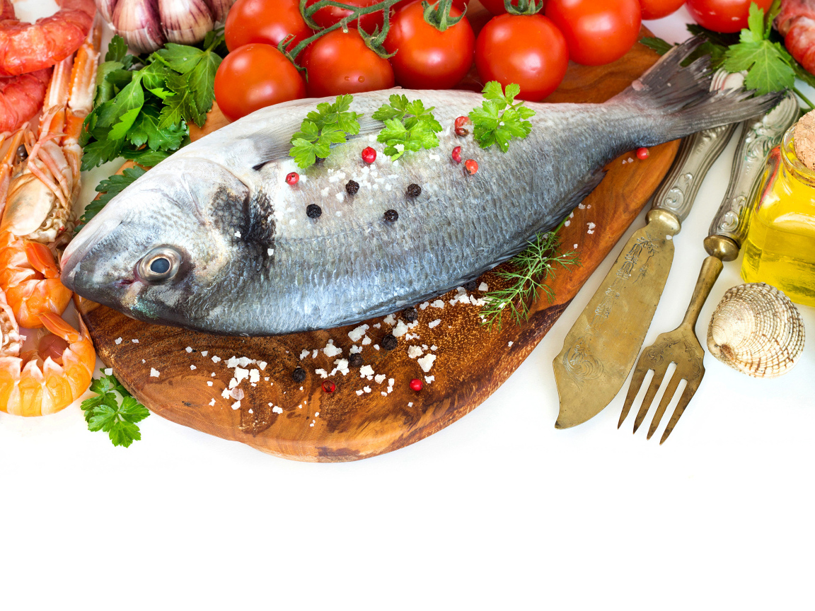 Сырая рыба на столе с маслом и помидорами 