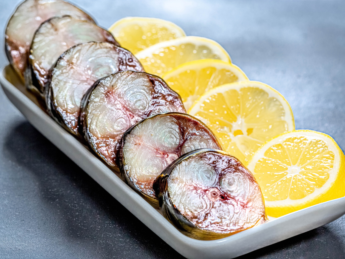 Sliced mackerel in a plate with slices of lemon