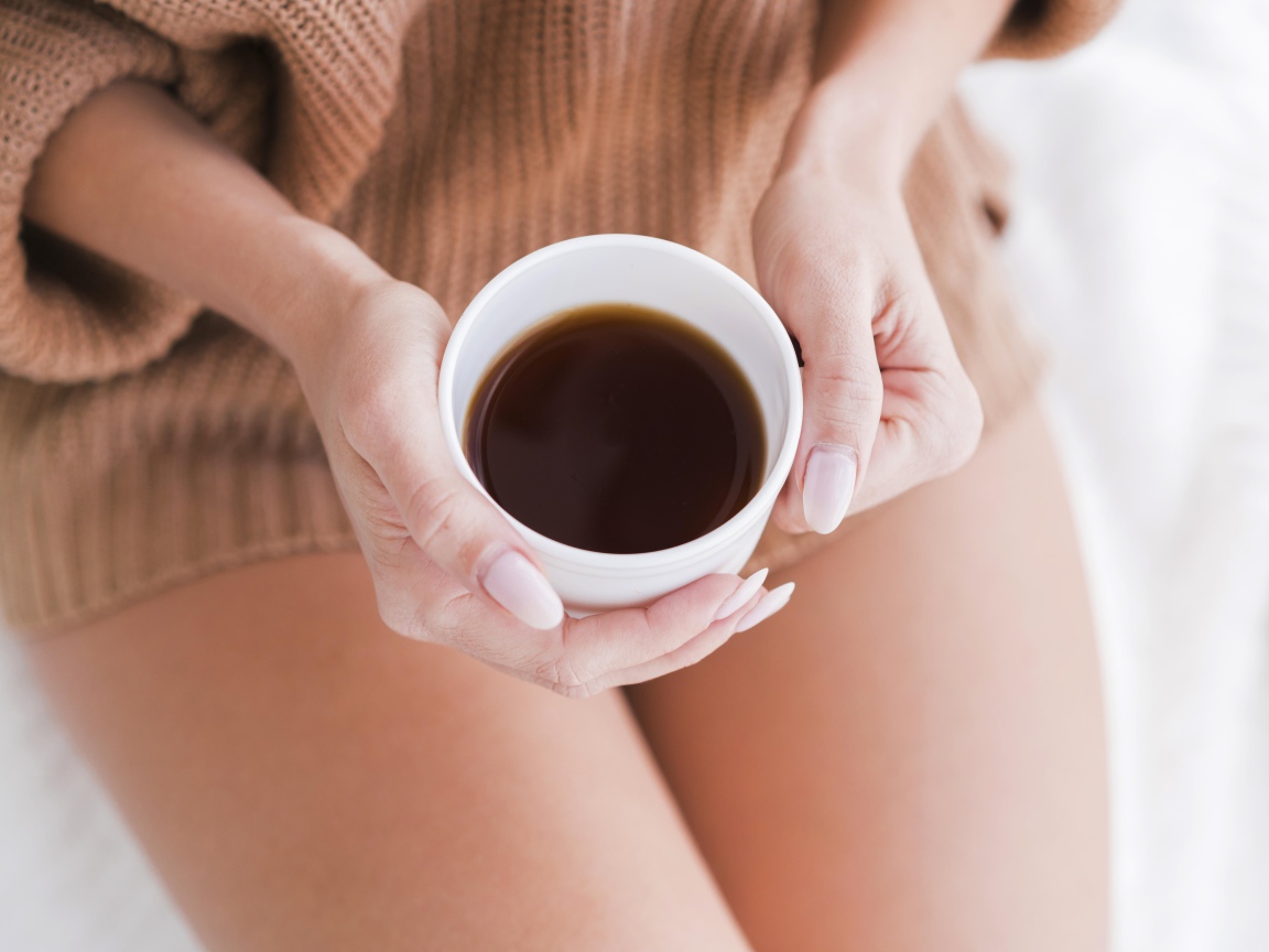 Чашка горячего кофе в руках у девушки 