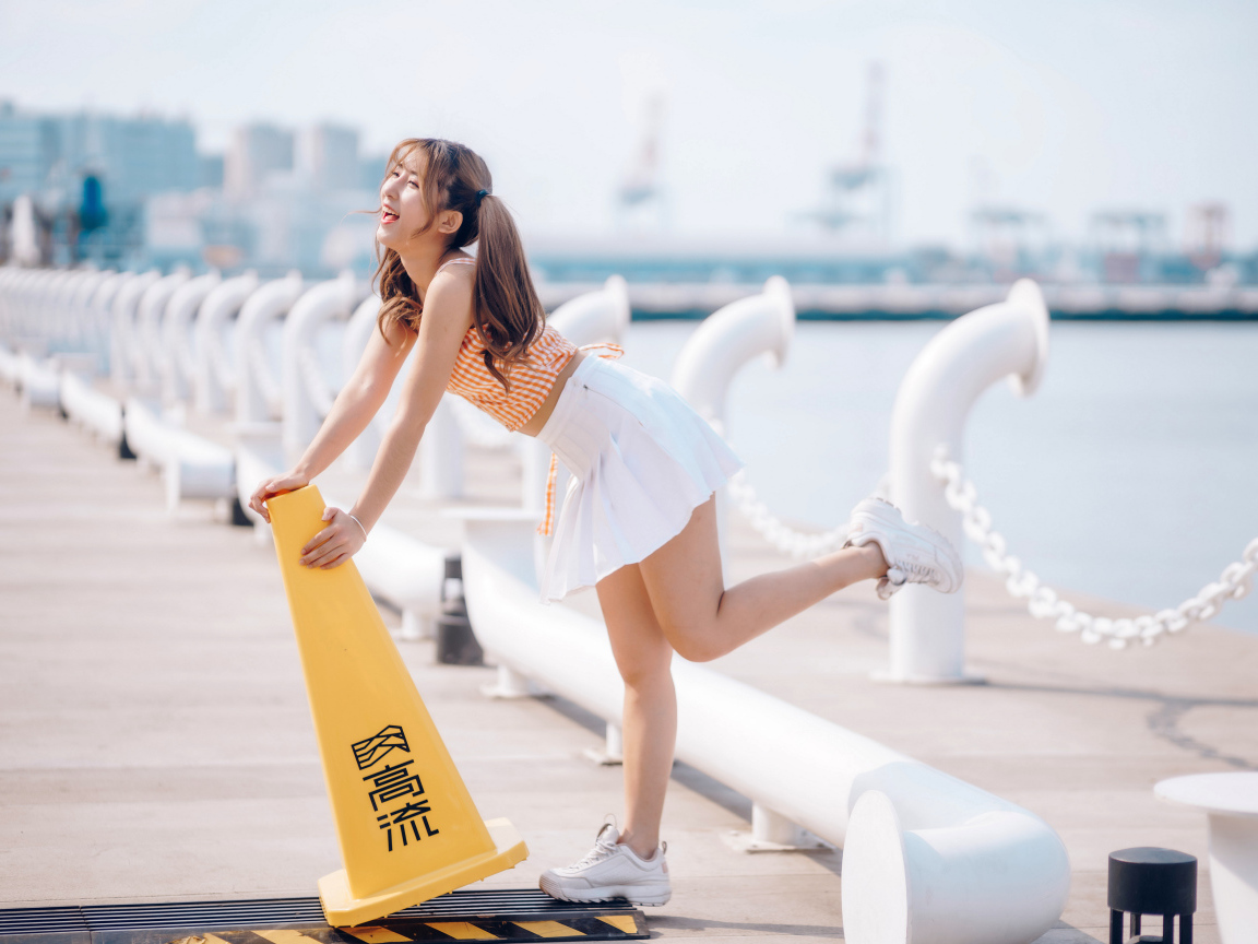 Азиатка с короткой белой юбке у воды 