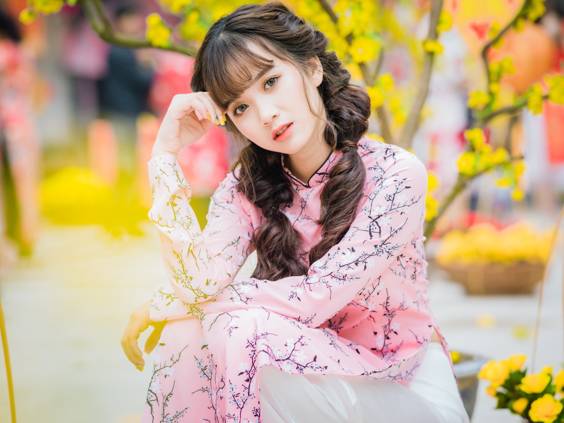 Красивая девушка азиатка в красивом розовом наряде в парке