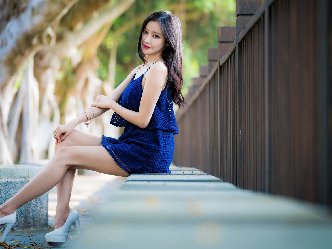 Красивая девушка азиатка в синем платье в парке