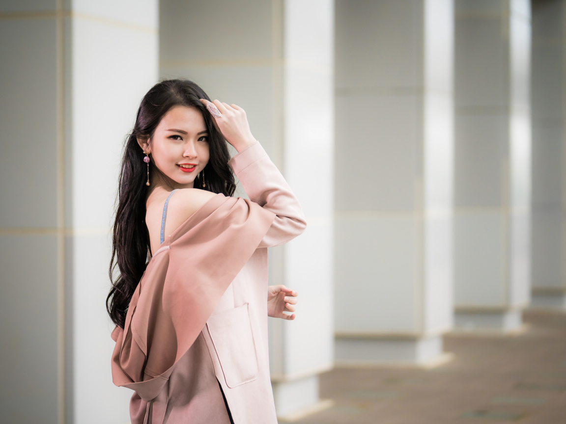 Красивая девушка азиатка с длинными волосами в розовом пальто 