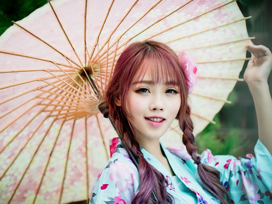 Красивая азиатка в большим зонтом 