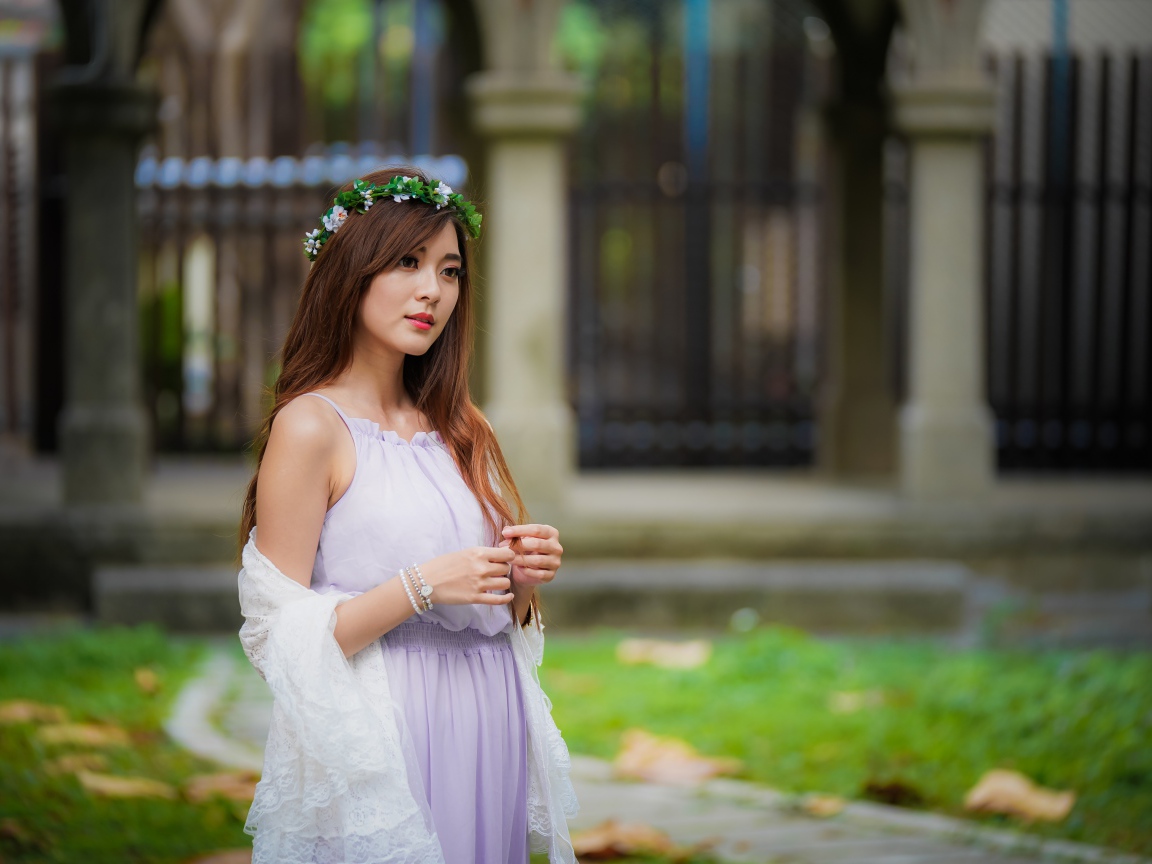 Красивая азиатка в сиреневом платье с венком на голове