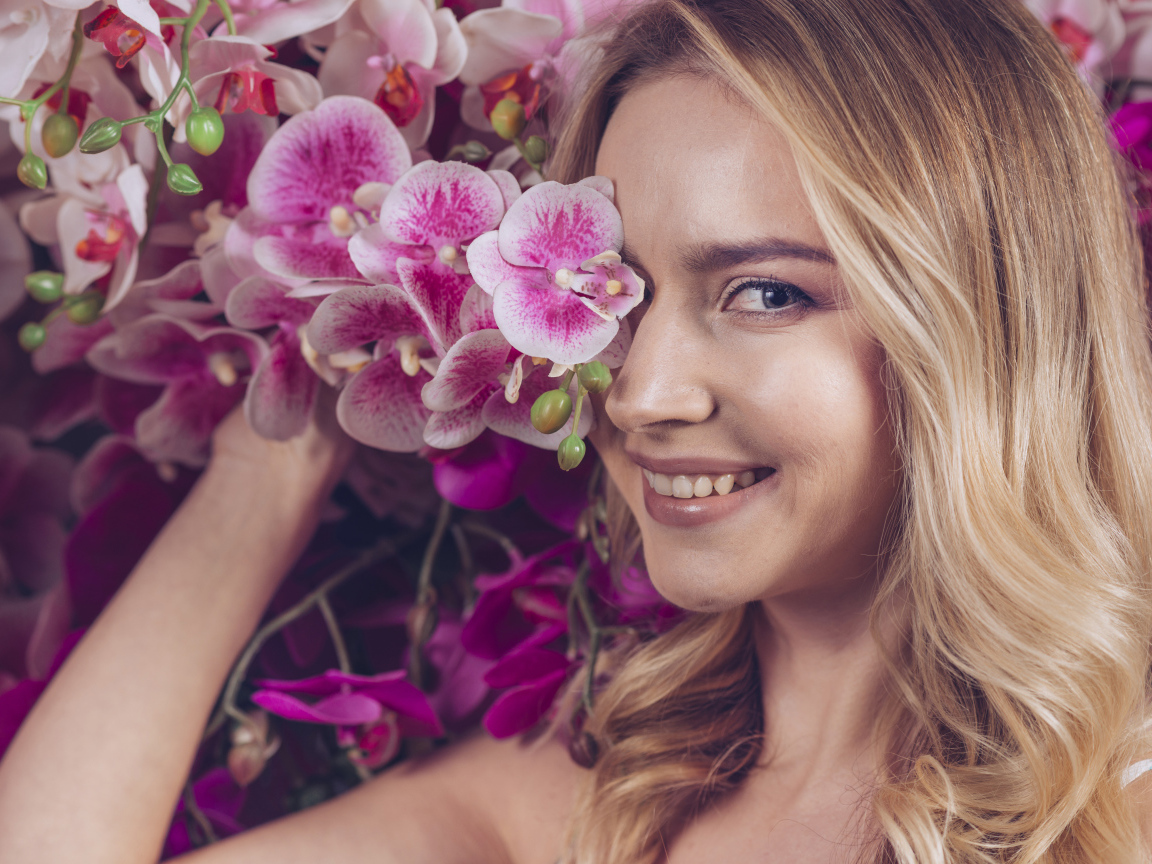 Beautiful blonde girl with orchid flowers
