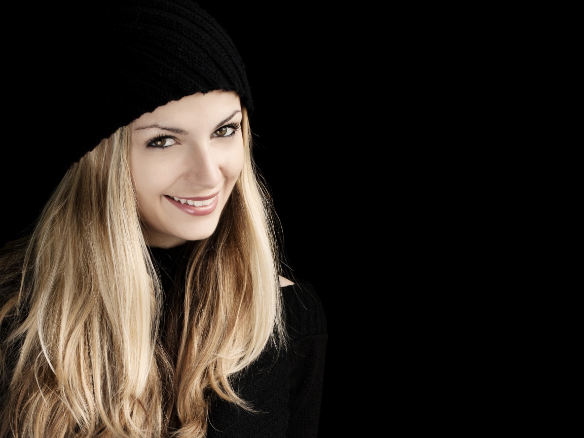 Красивая блондинка в шапке на черном фоне