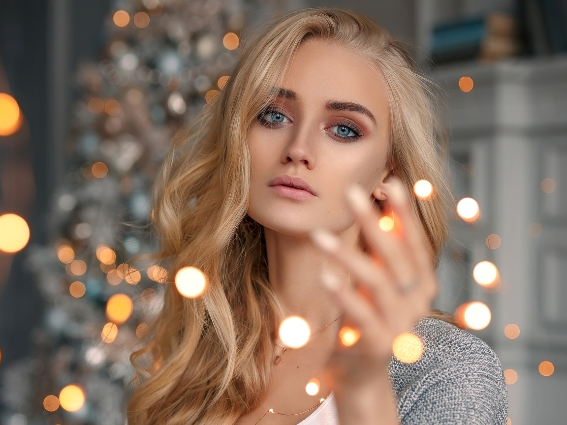 Красивая голубоглазая блондинка с гирляндой в руке