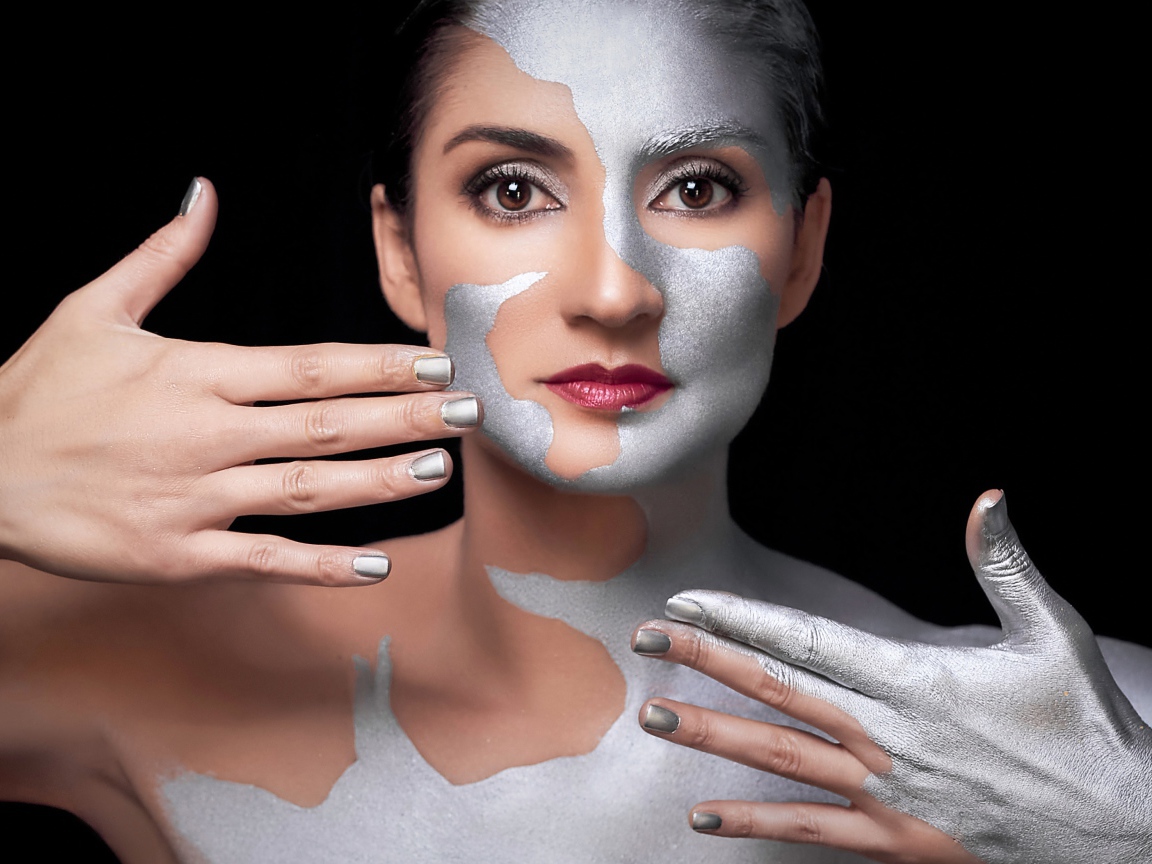 Красивая кареглазая женщина с серебристой краской на теле 