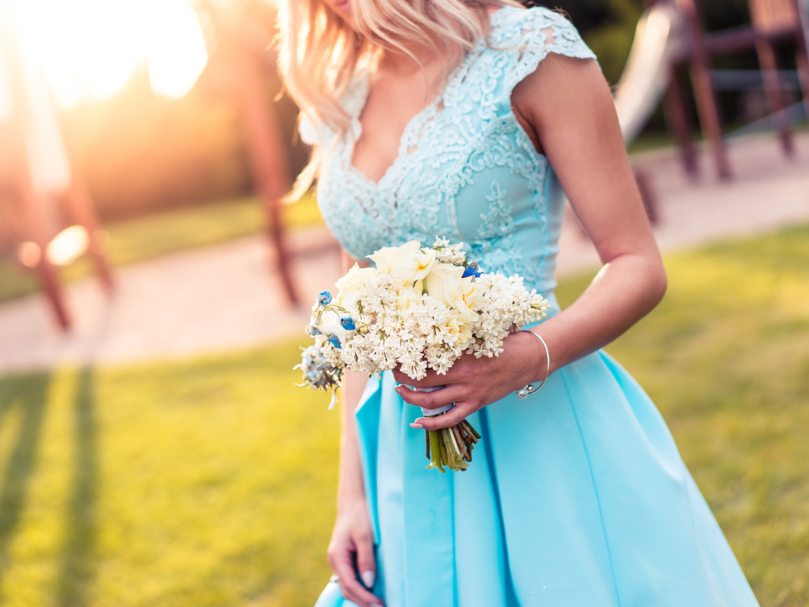 Красивая девушка в голубом платье с букетом в руке