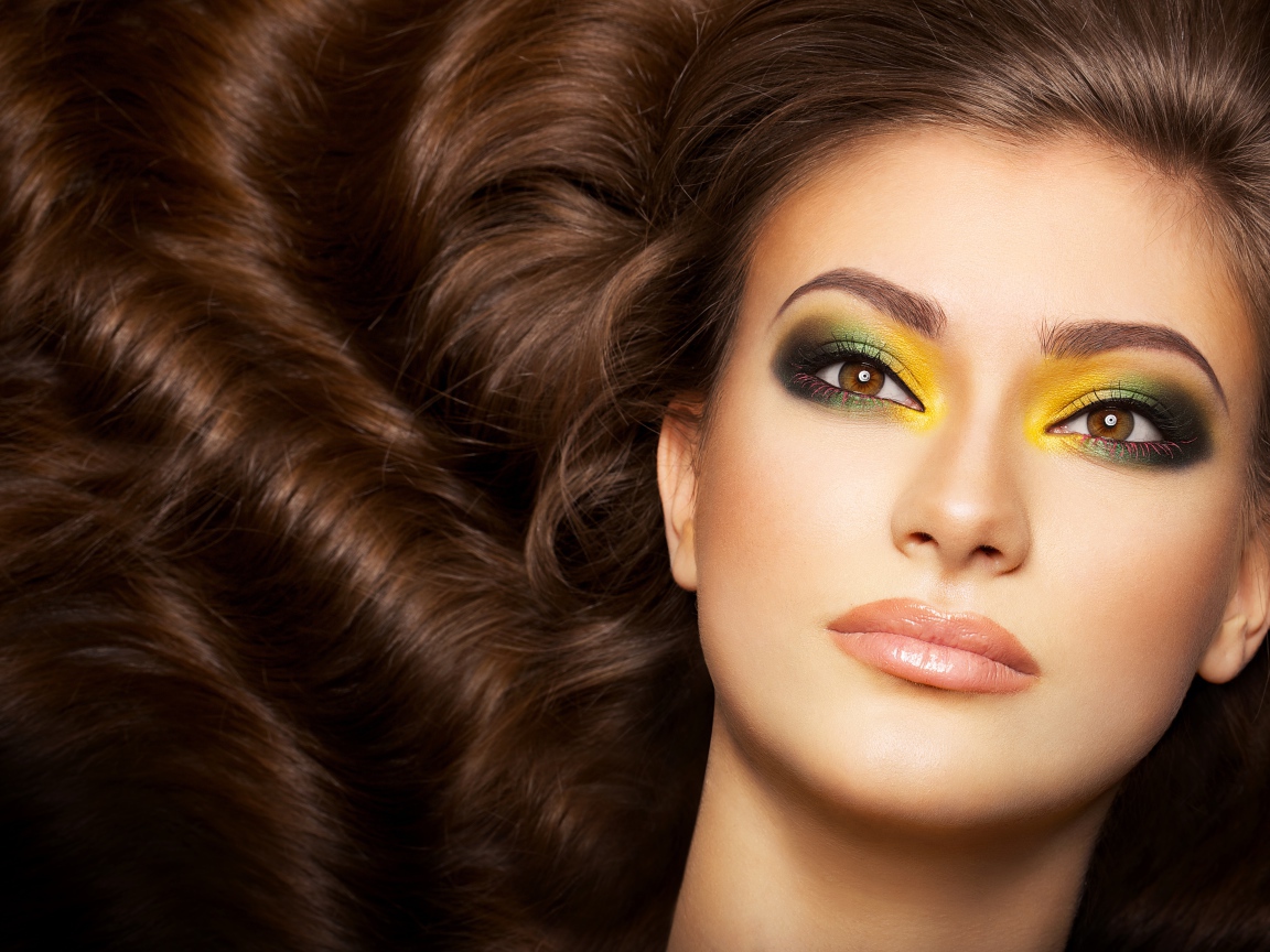 Красивая длинноволосая девушка с ярким макияжем на глазах 