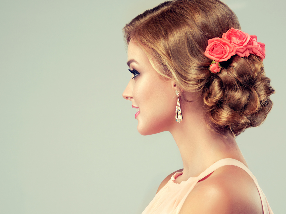 Красивая свадебная прическа у молодой девушки на сером фоне 