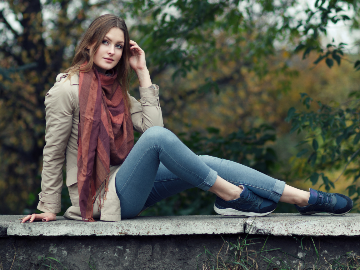 Милая девушка в куртке и синих джинсах 