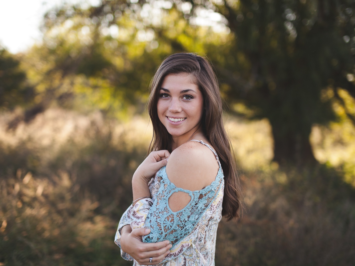 Милая улыбающаяся девушка в лесу 