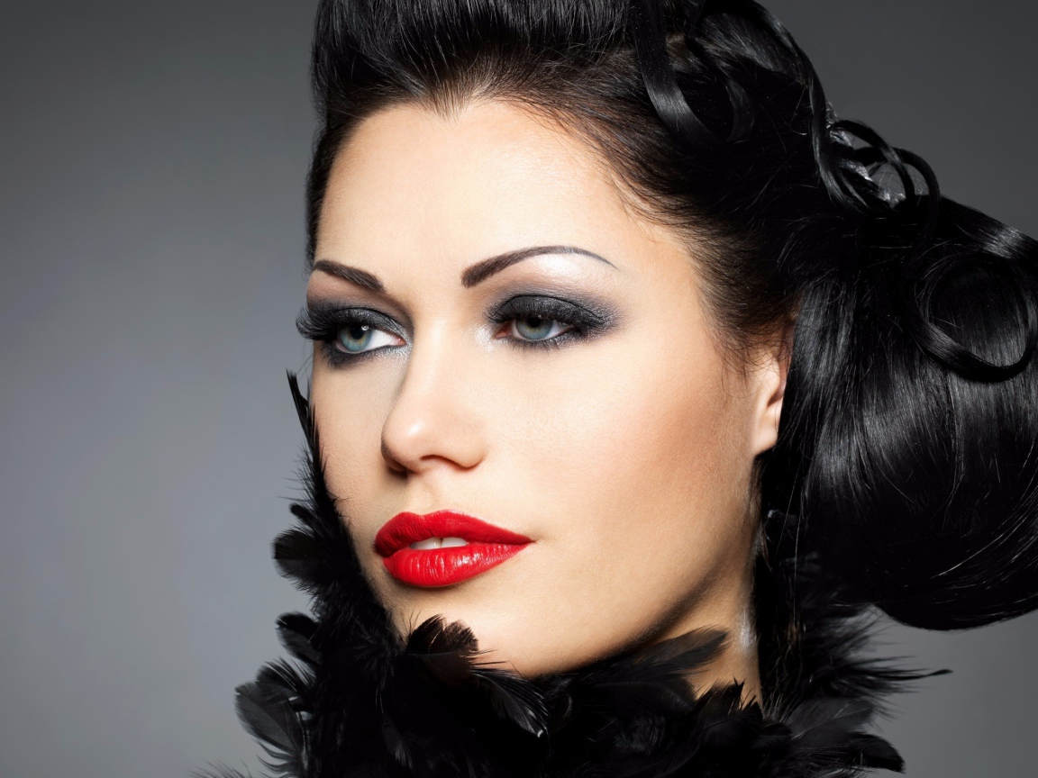 Лицо брюнетки с красивой прической на голове на сером фоне