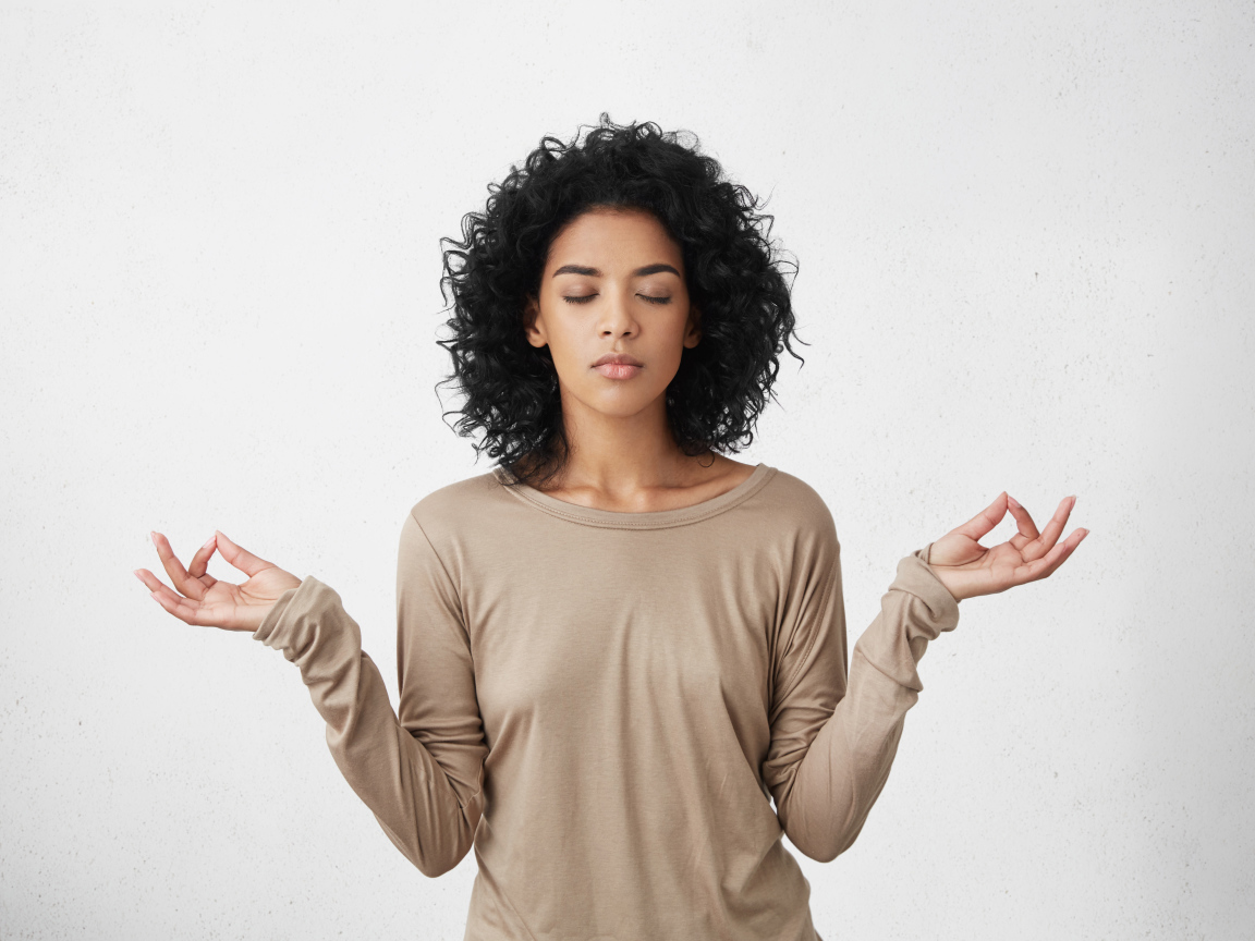 Девушка с закрытыми глазами медитирует 