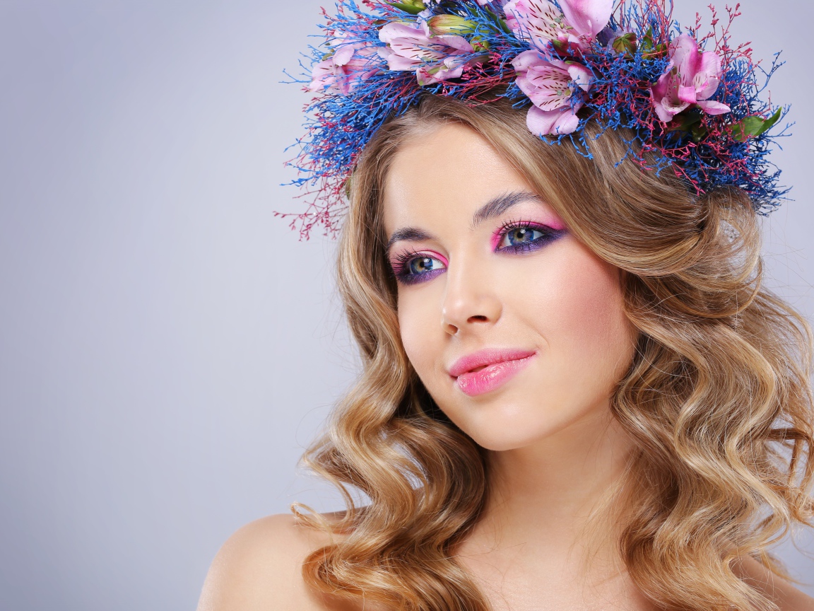 Милая девушка с венком на голове на сером фоне 