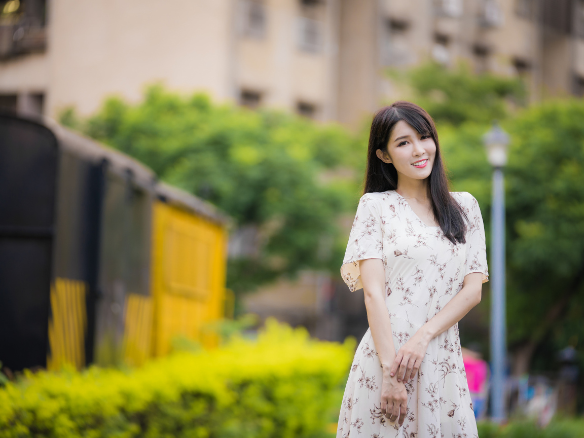 Нежная улыбающаяся азиатка в красивом платье 