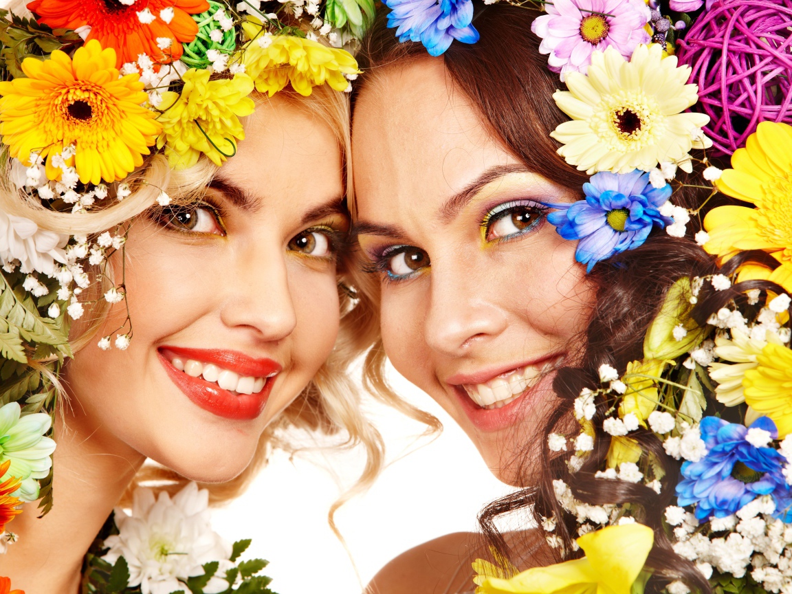 Две яркие улыбающиеся девушки с цветами в волосах 