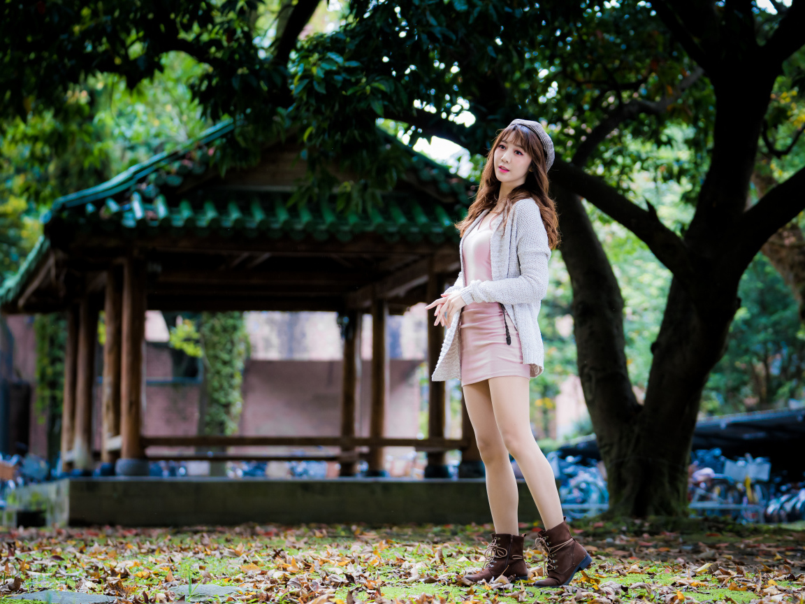 Молодая азиатка в теплой кофте в парке