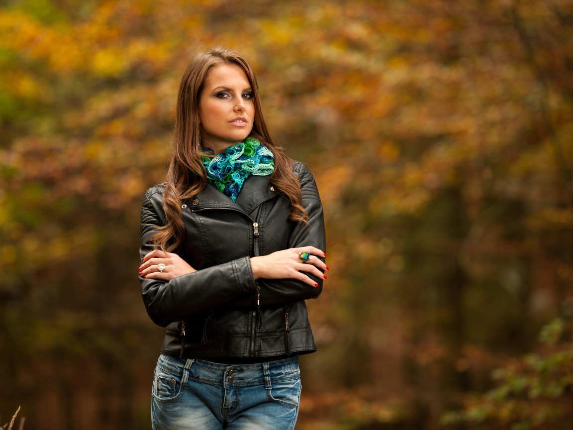 Молодая девушка в черной кожаной куртке  в парке