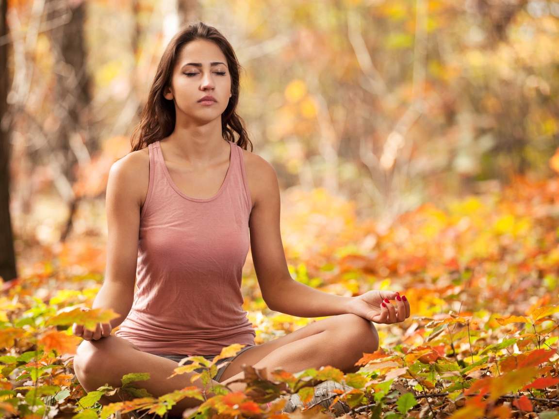 Молодая девушка медитирует в лесу 