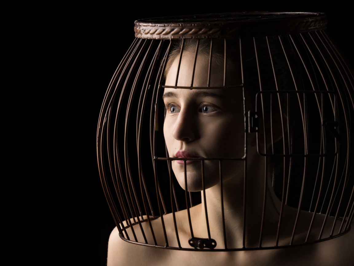 Молодая девушка с клеткой на голове 