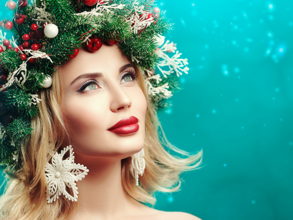Красивая девушка с венком из еловых веток на голове на голубом фоне