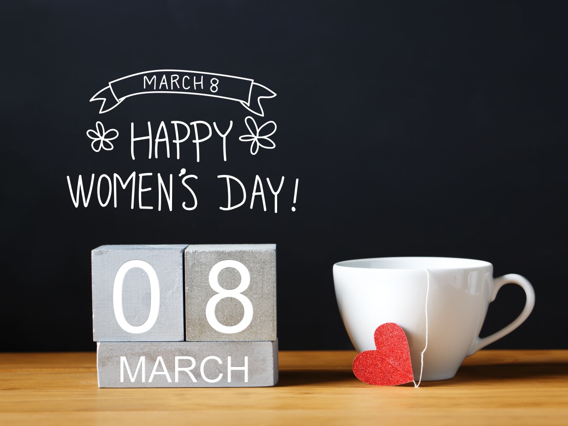 Чашка чая на столе с кубиками на Международный женский день 8 марта